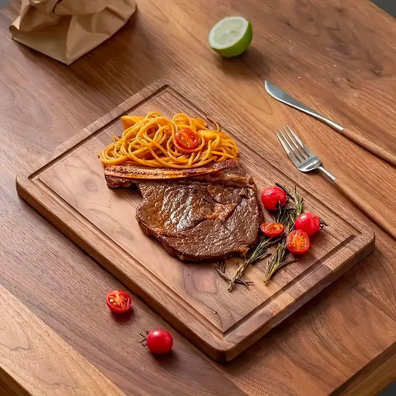 Planche à découper en bois massif avec des la viande et des tomates